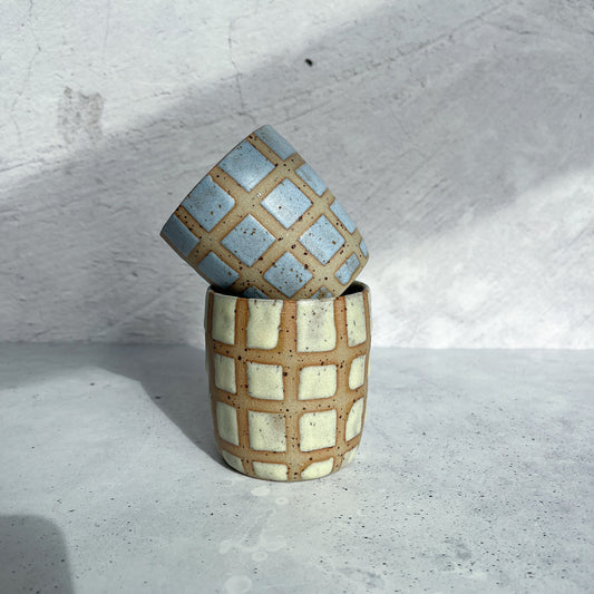 Mugg med BOTZ 9862 Desert Yellow på prickig lera vid 1250 °C. Bilden visar även en annan mugg.