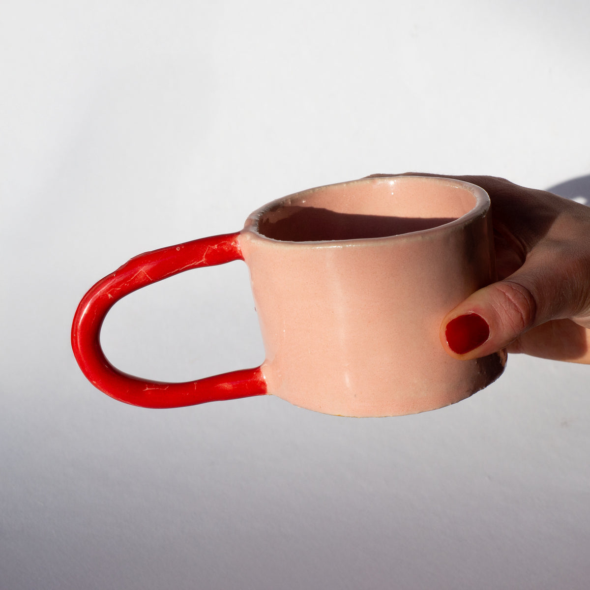 Mugg med BOTZ 9873 Vermilion och 9876 White glossy på vit chamotterad lera vid 1250 °C.