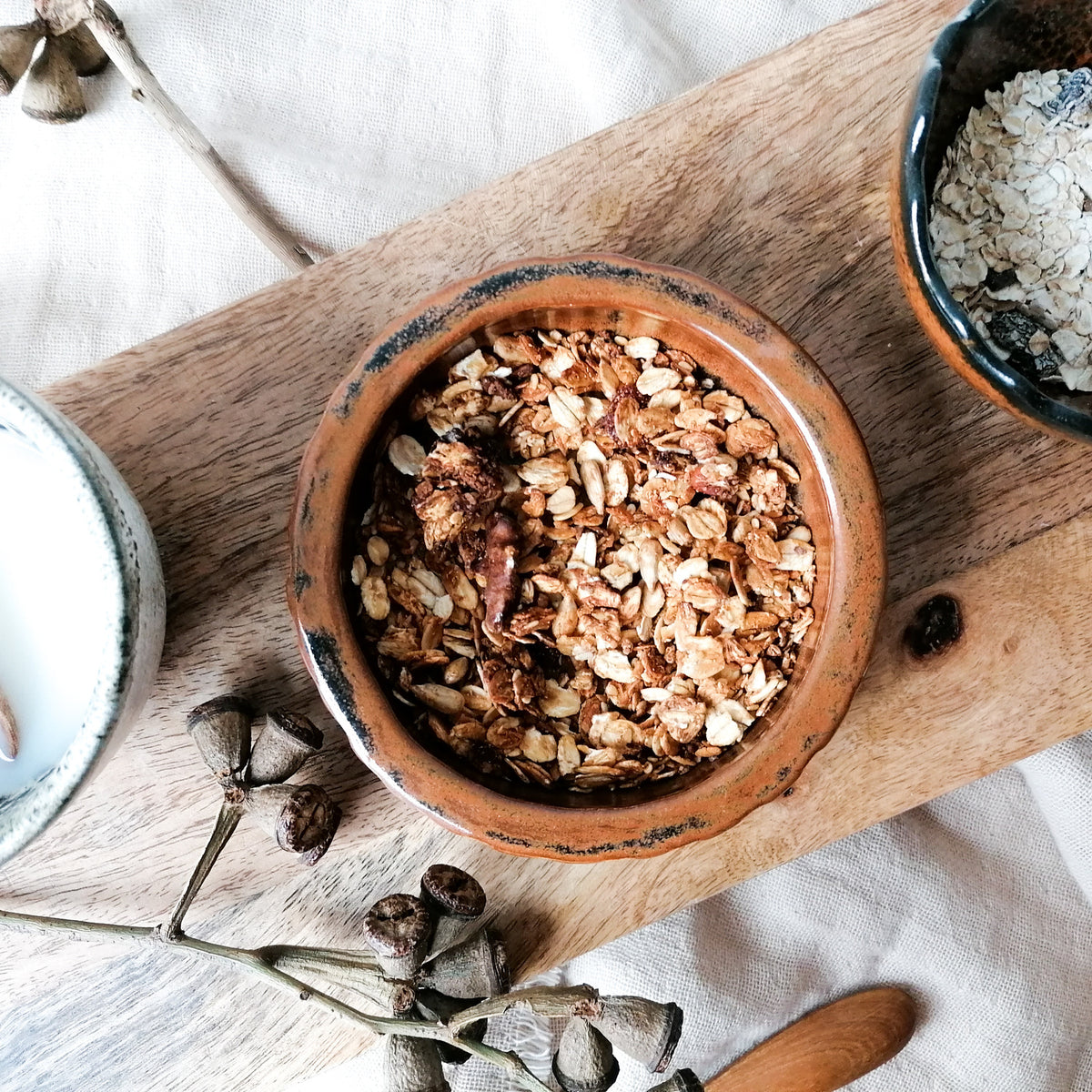 Skålen med granola visar BOTZ 9885 Tenmoku på vit lera vid 1250 °C. Bilden innehåller fler alster.