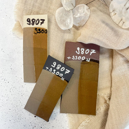 BOTZ EDITION. Jämförelse av 9807 Toffee med transparent 9300 på vit, röd och mörk lera vid 1250 °C. Underlaget påverkar färgen.