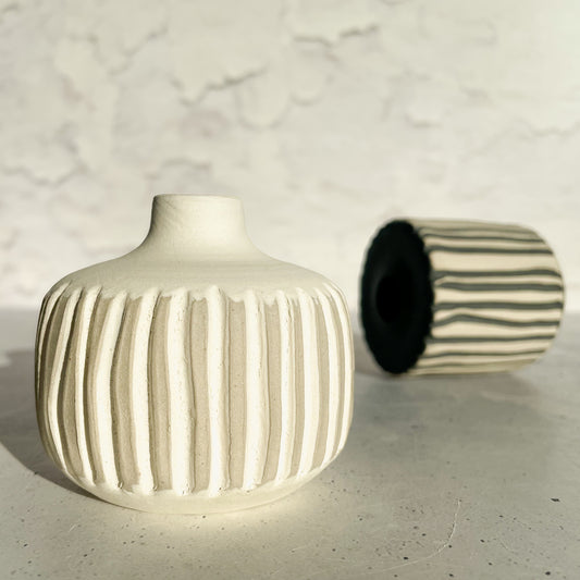 BOTZ EDITION. 9801 White på den vita räfflade vasen i förgrunden, vit lera bränd vid 1250 °C. Det svarta alstret bakom visar en annan färg.