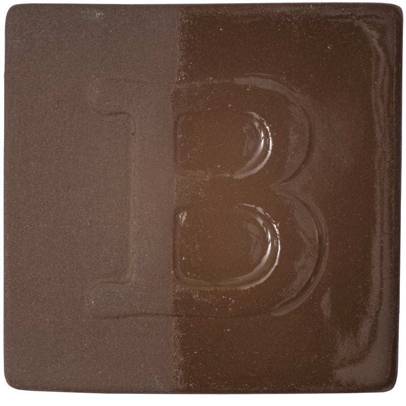 BOTZ engober. BOTZ:s provplatta med 9052 Dark Brown. Vänsterhalvan visar oglaserad engobe; högerhalvan visar samma engobe med ett tunt lager transparent glasyr.