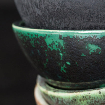 Den gröna och metalliskt mörka skålen i mitten visar 9577. Övriga skålar visar andra glasyrer. Bränd vid 1100 °C enligt BOTZ:s bildunderlag.